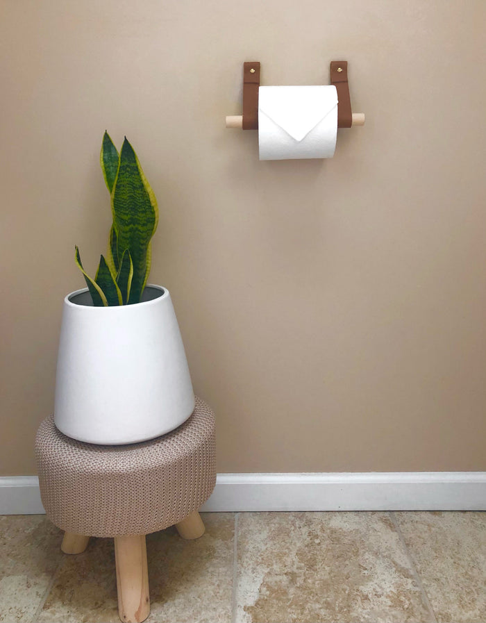 Sustainable leather bathroom holder mounted on the wall beside a sink.