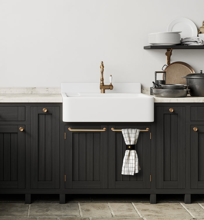 Keyaiira Wide Leather Towel Hugger mounted beneath farmhouse sink vanity, holding hand towel with solid brass rivet — minimalist bathroom organization in dark cabinetry.