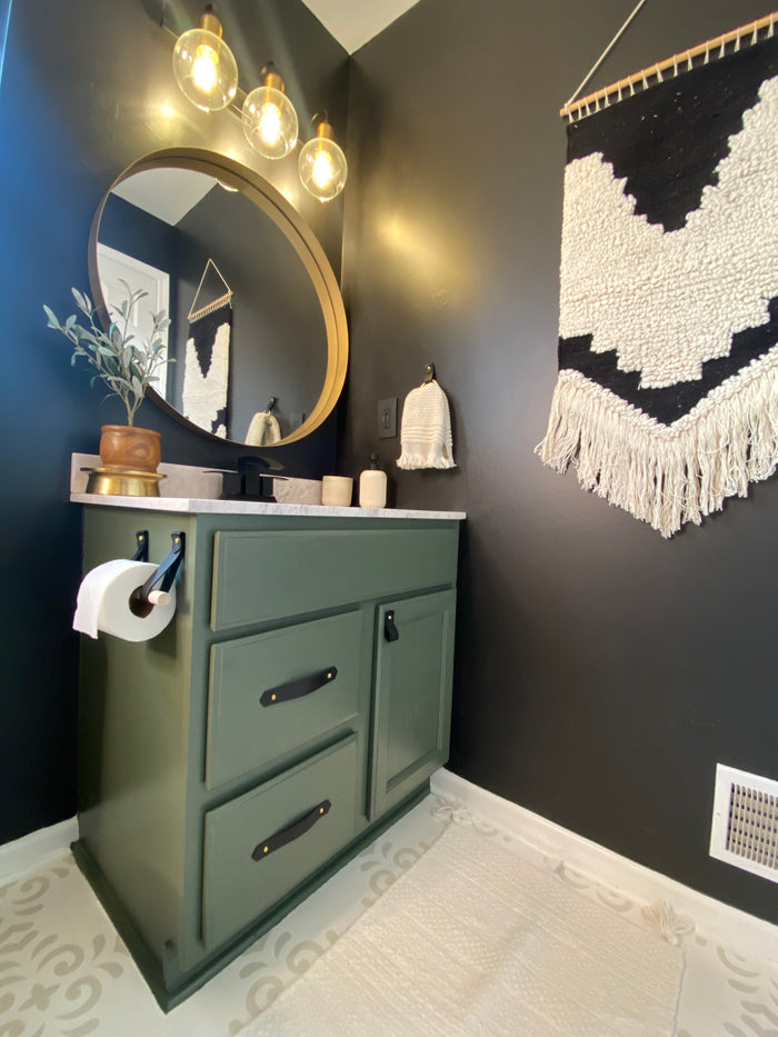 Bathroom styled with Keyaiira leather towel ring and toilet paper holder set in black finish. Handcrafted leather hardware adds timeless, minimalist detail to green cabinetry and neutral tile.