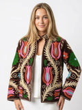 Woman wearing a colorful embroidered jacket on a white background