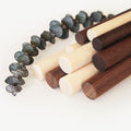 Solid wood dowels in walnut, maple, birch, and dark stain finishes — modern wooden rods for suspended storage systems, wall rails, and leather strap shelving.